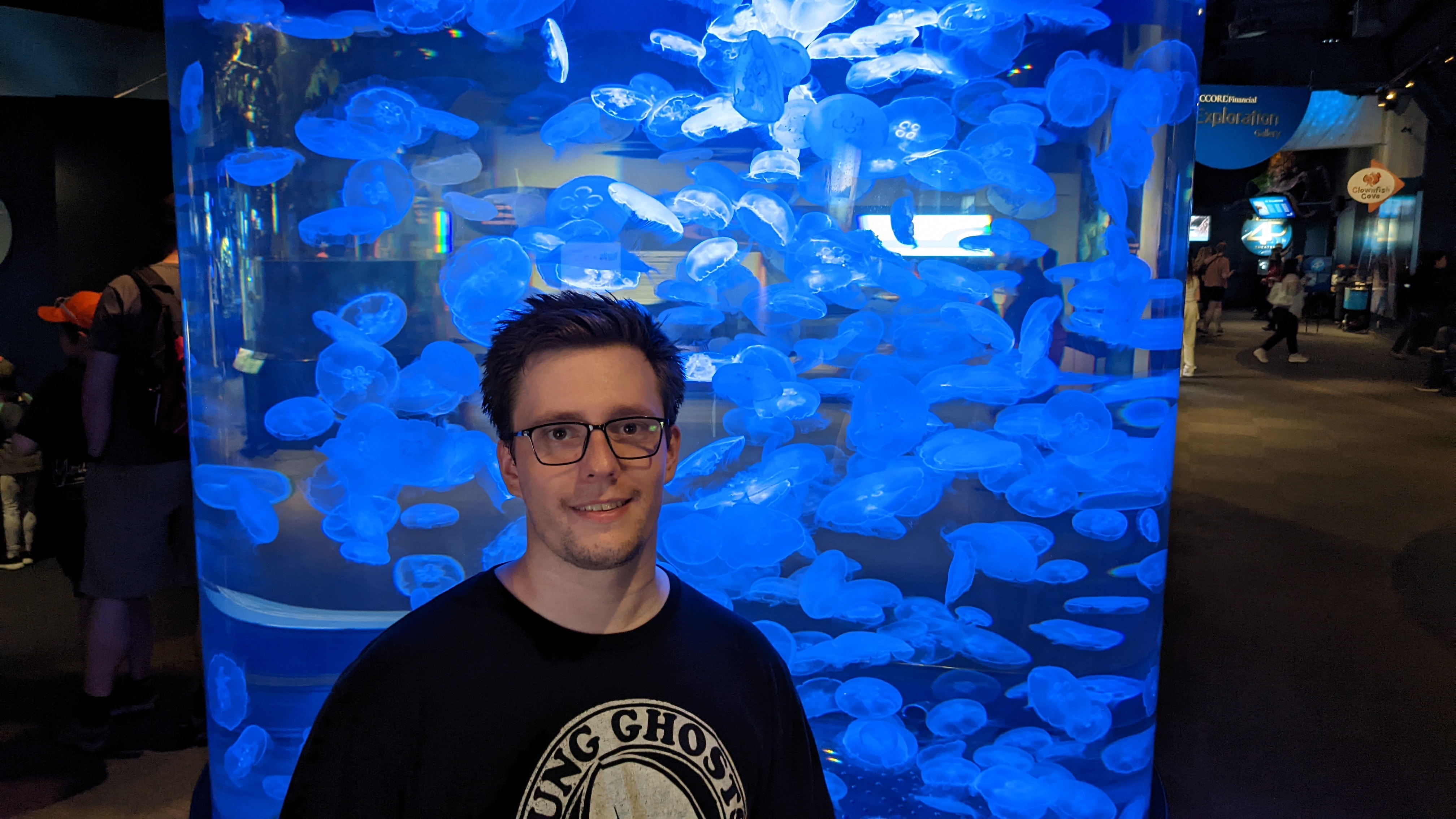 Bradley James in front of a jellyfish tank